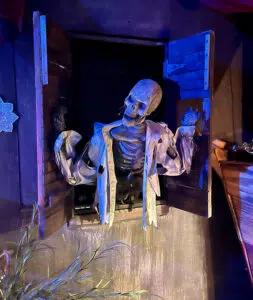 A skeleton peeking out of a window at American Monsters: Onionhead's Revenge