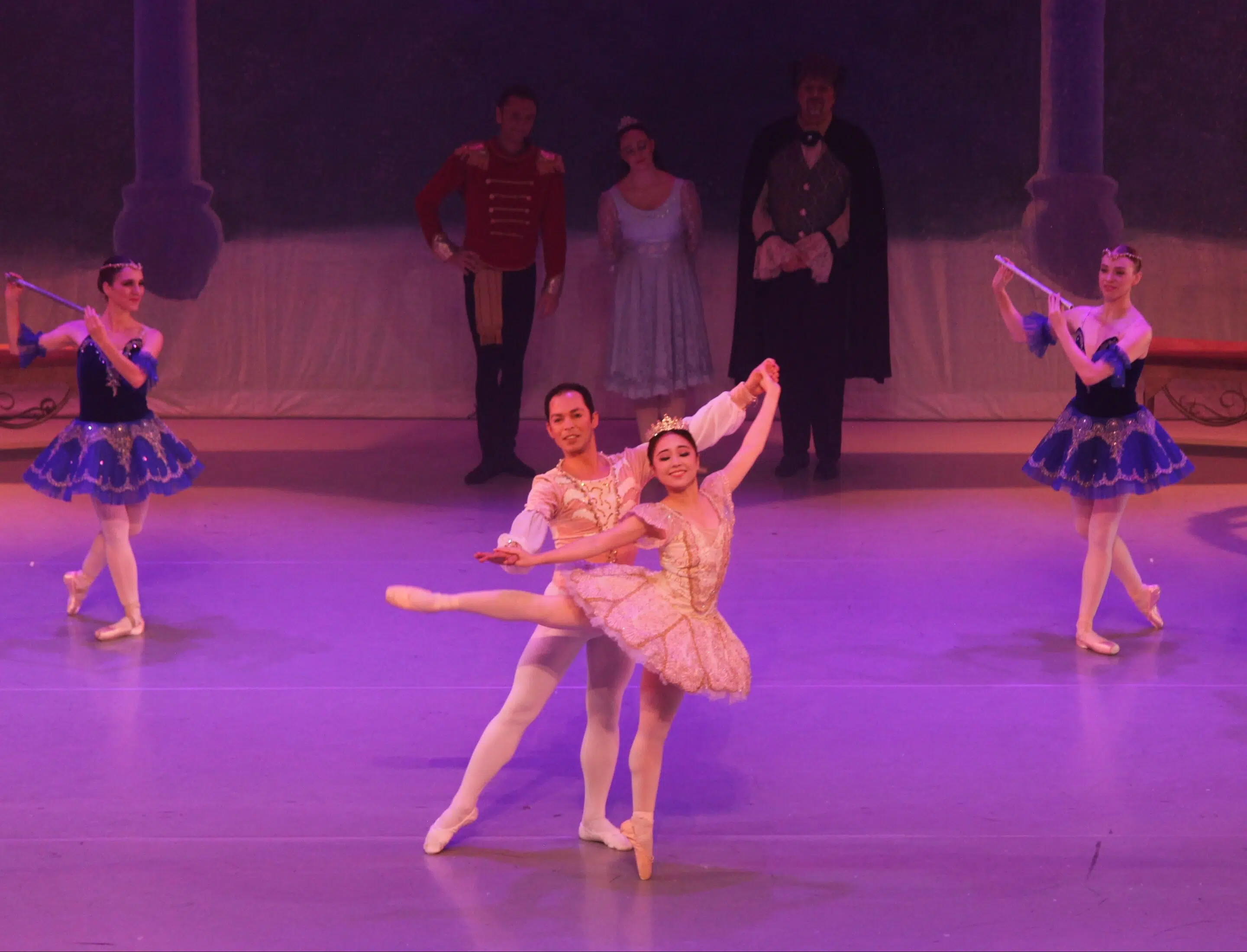 A man and woman dance together dressed in white