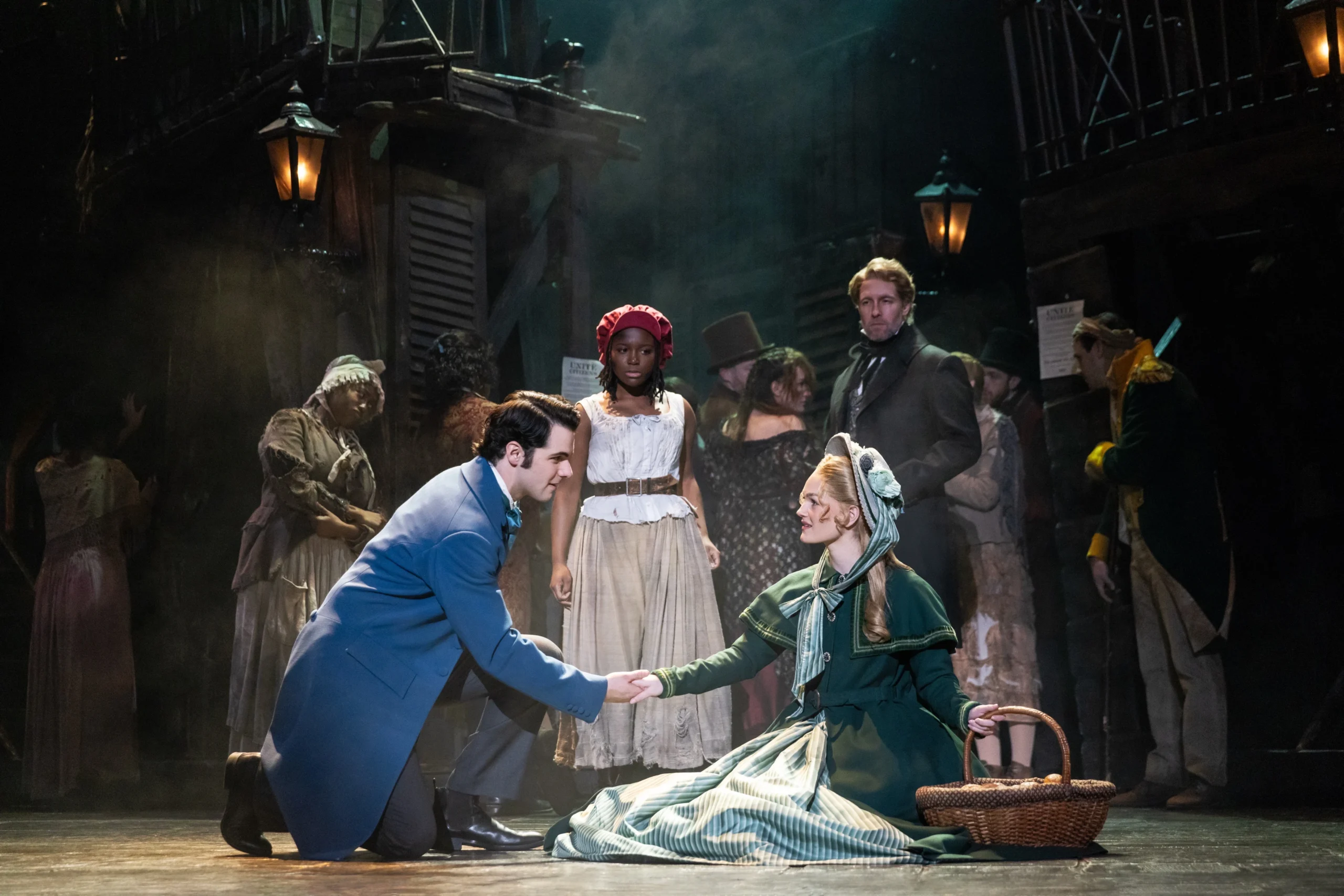 A well-dressed man helps a woman in shabby clothes get off the floor