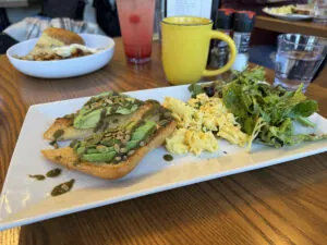 Avocado toast, scrambled eggs, and a mug of coffee