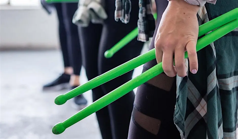 Close up of a person's hand holding drumsticks