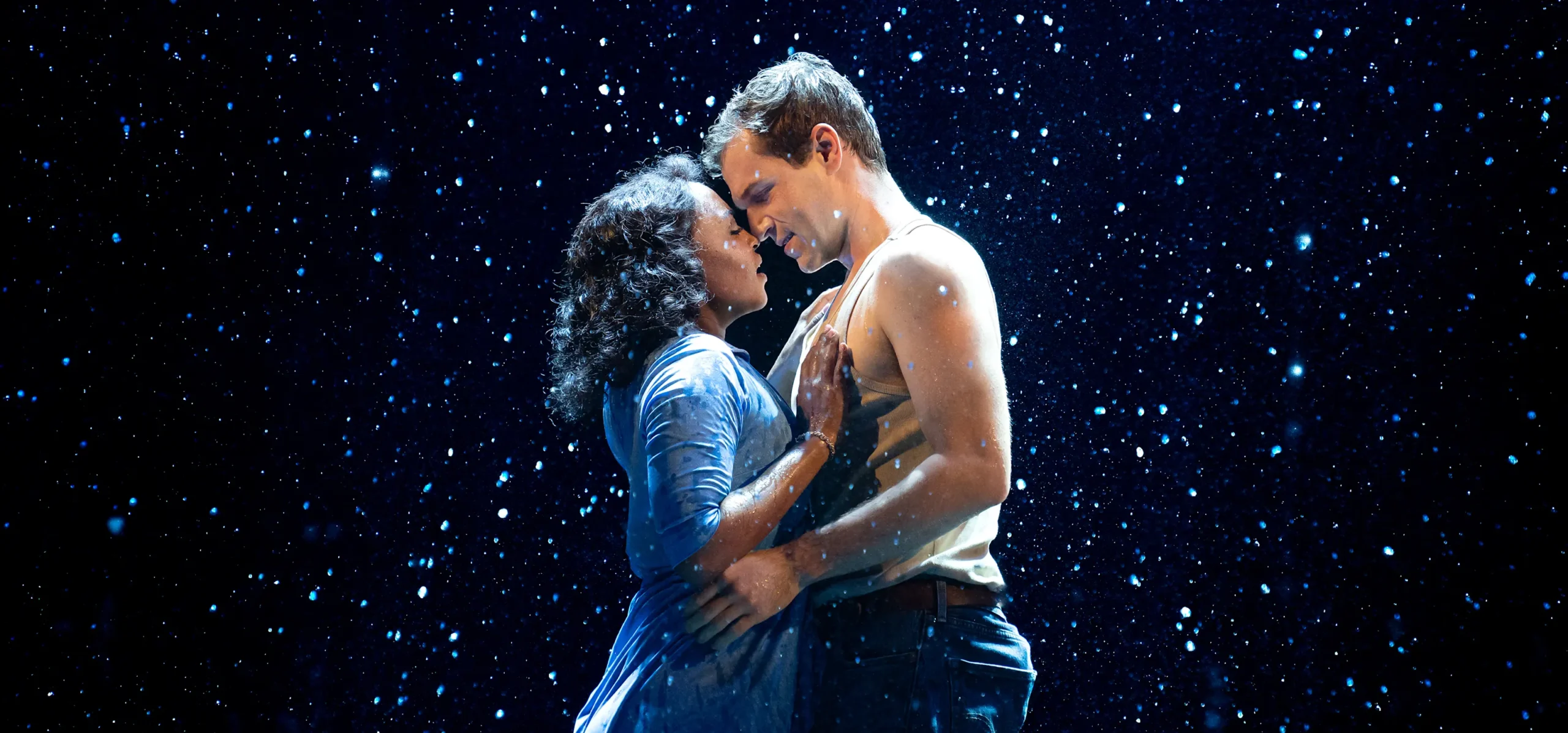 A couple embraces against a starry background