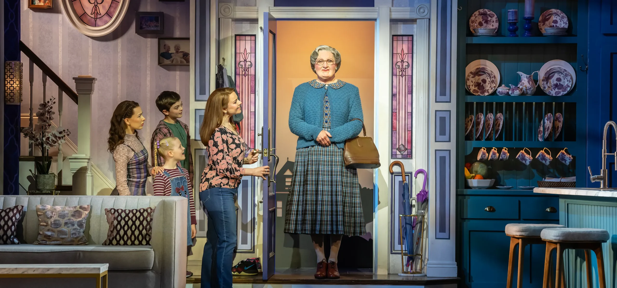 An elderly woman walks in a door held open by a woman and her 3 children