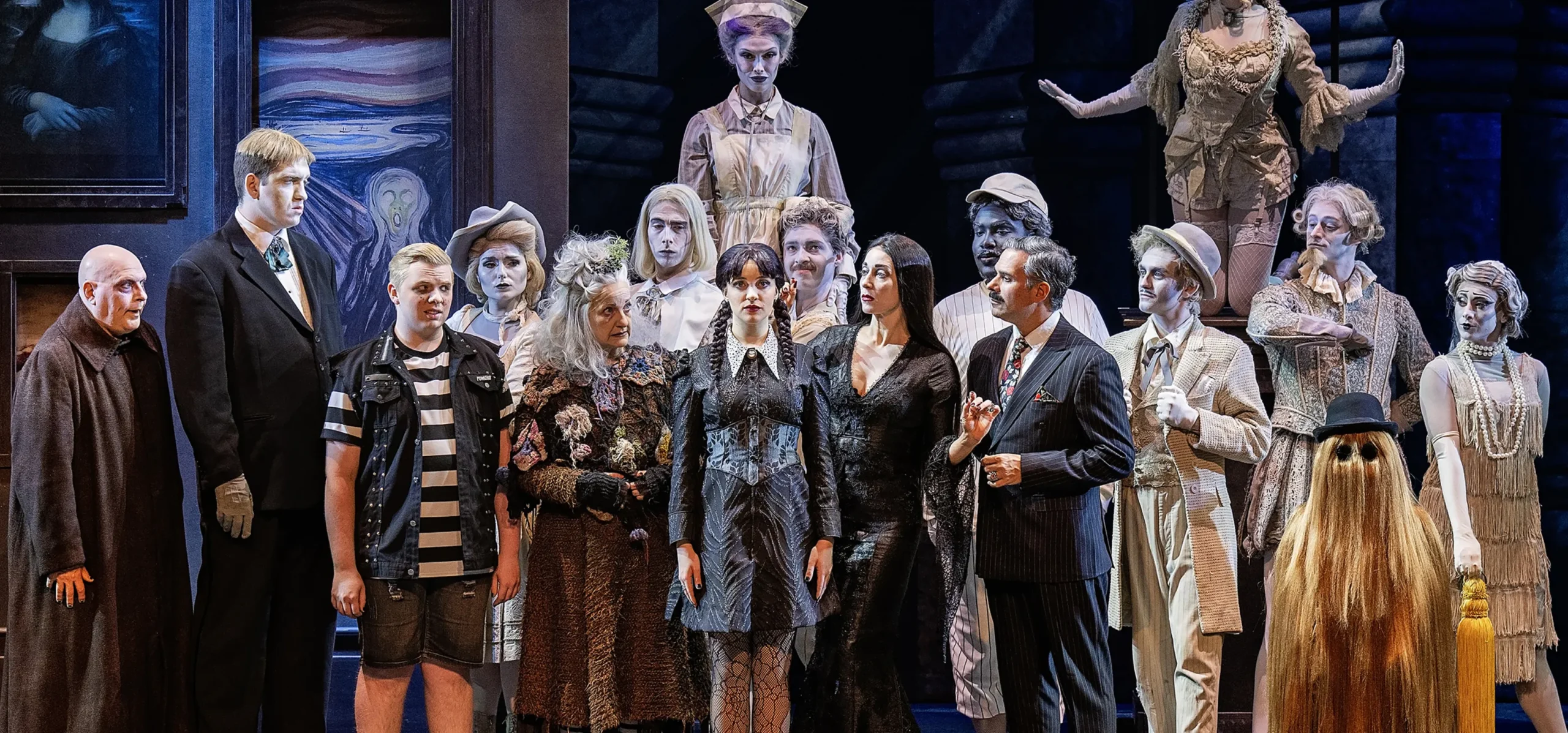 The cast of The Addams Family stares at Wednesday Addams