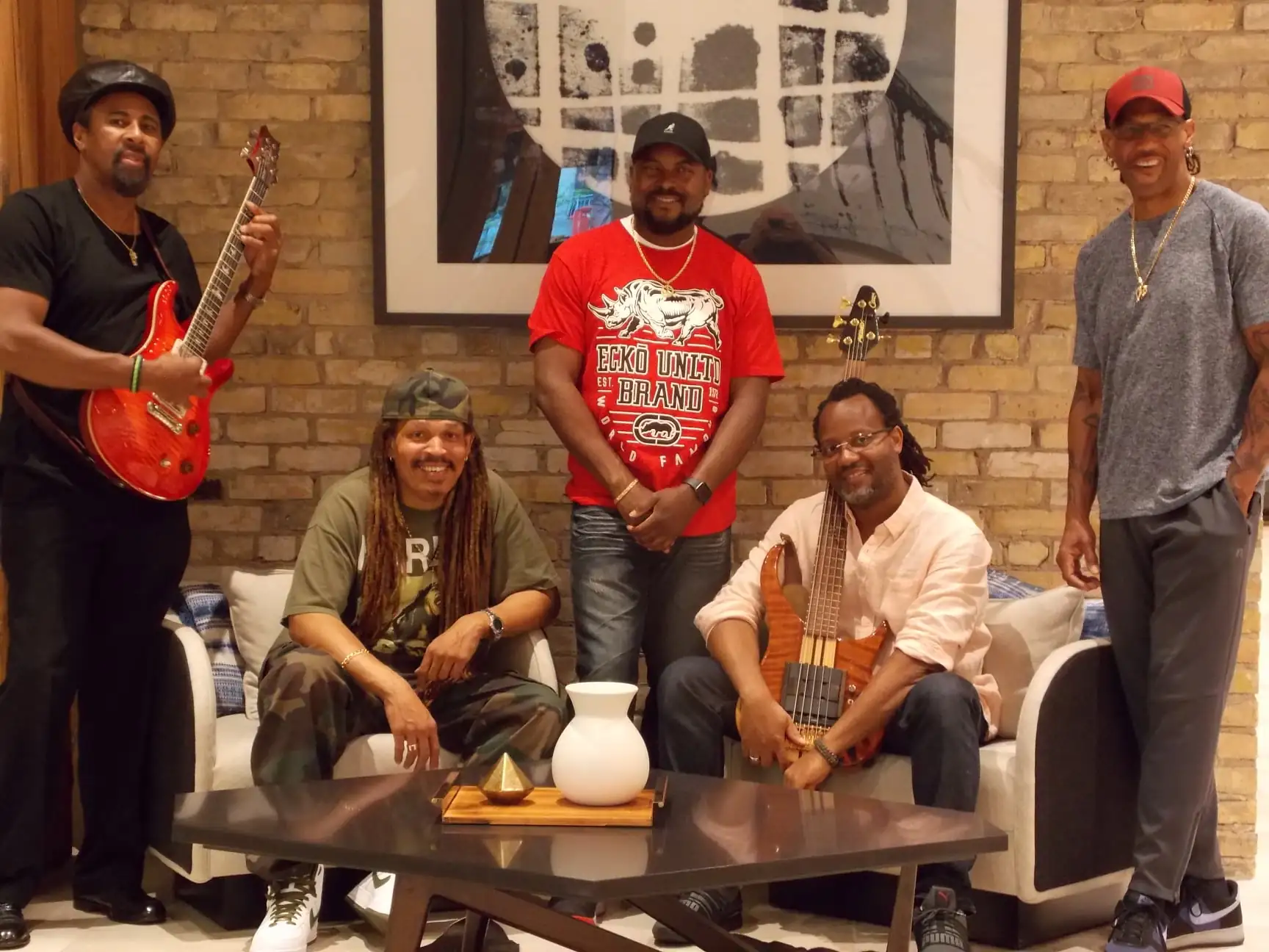 A group of 5 musicians pose with their instruments
