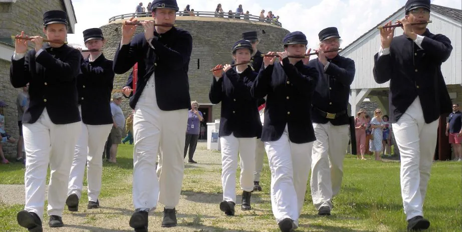 A group of traditionally dressed Civil War soldiers march while playing flutes