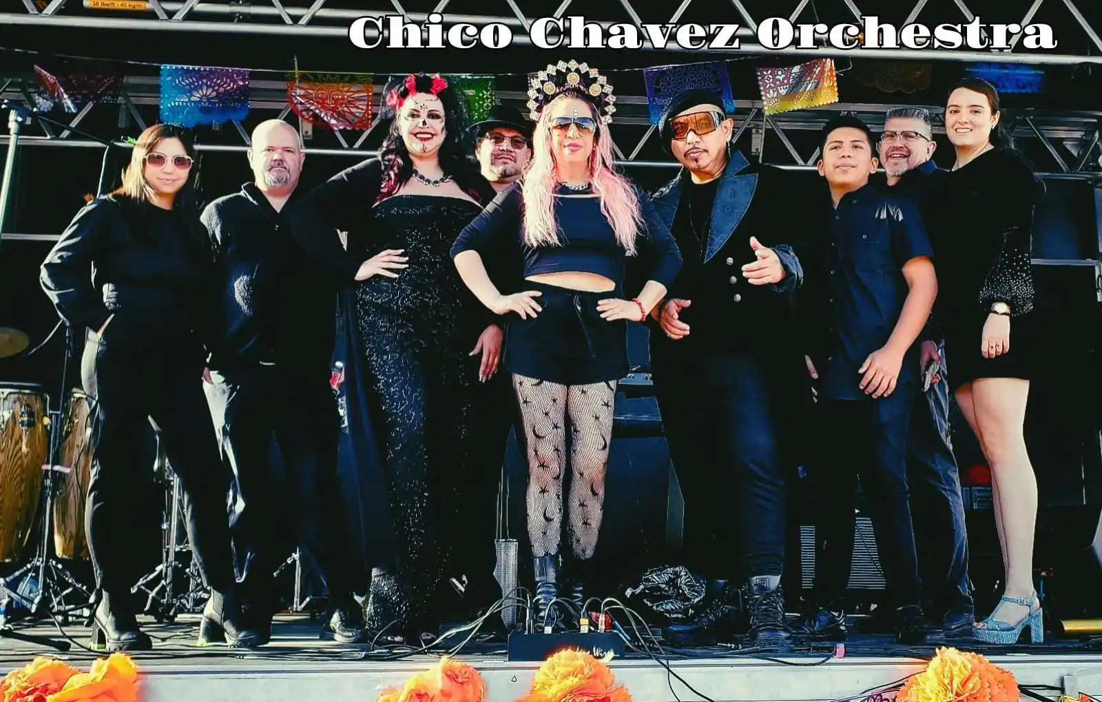 A 9-piece band dressed all in black smiles and poses