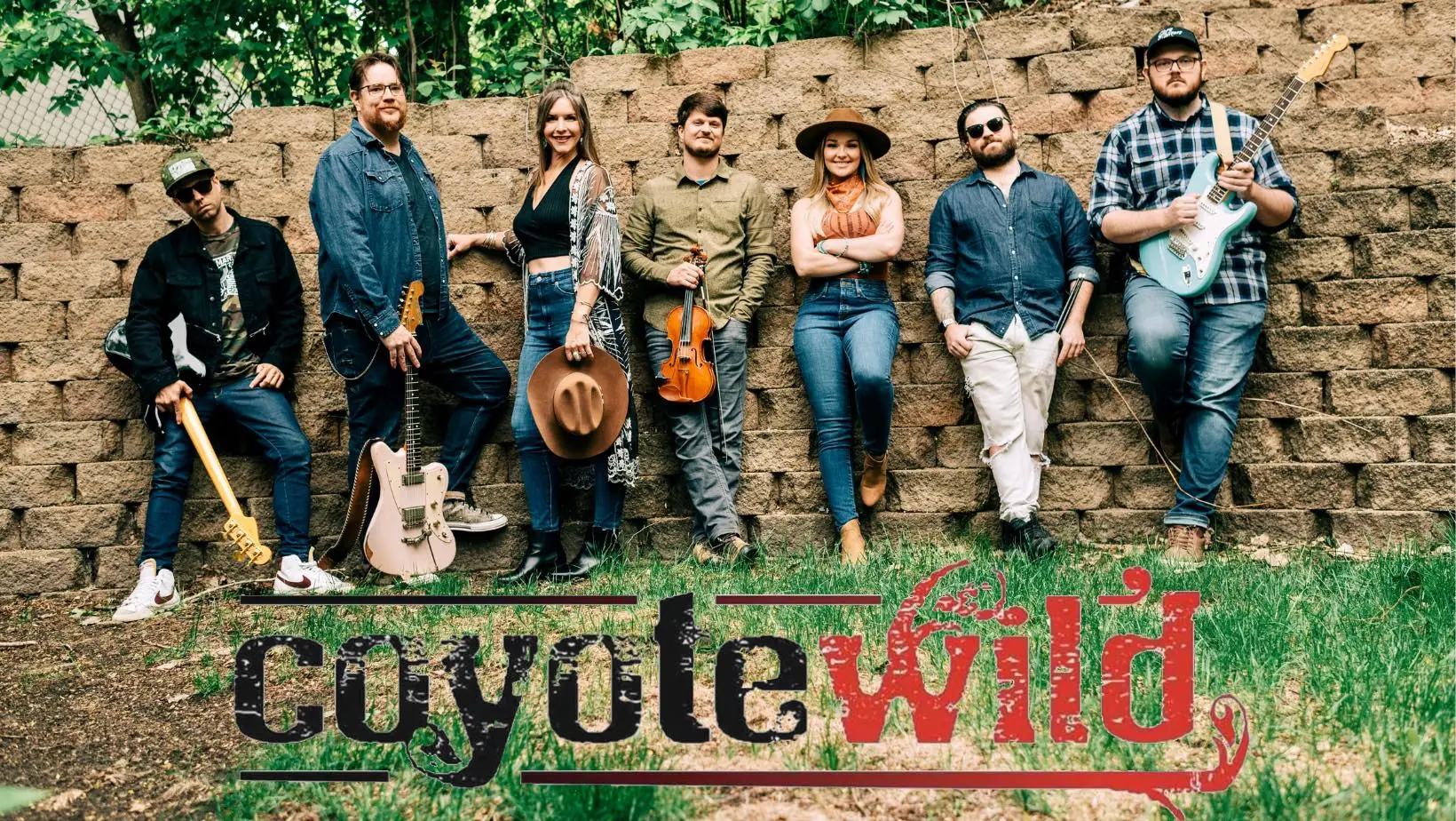 A 7-piece country band smiles and poses with their instruments