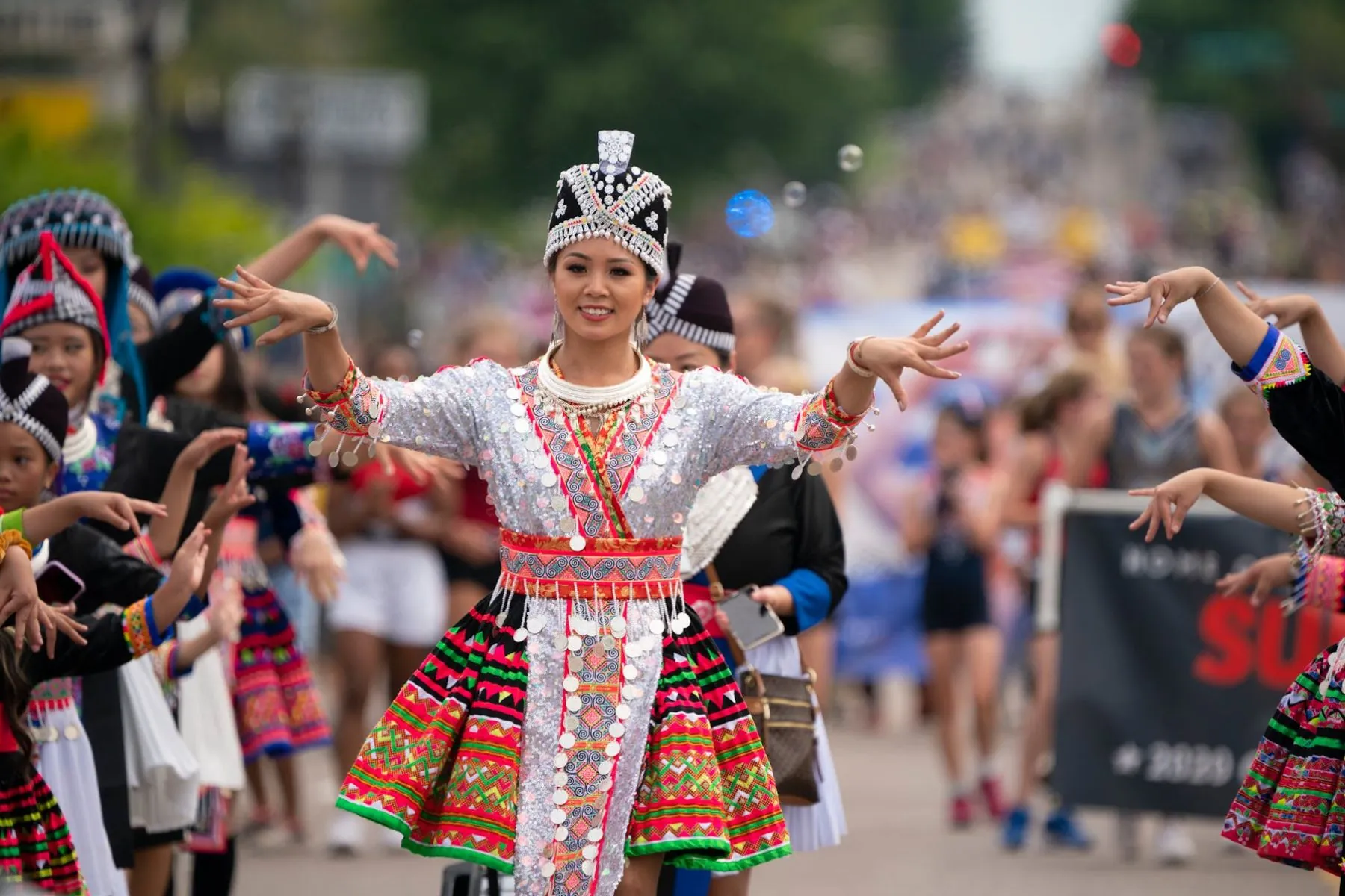 A woman in traditional Hmong dress marches in a parade