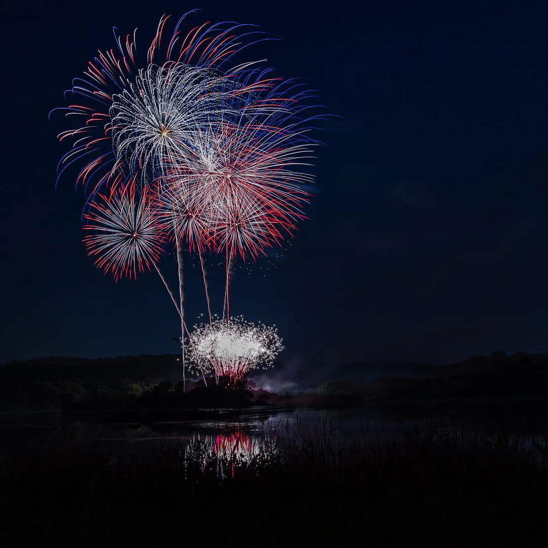Fireworks go off above a lake