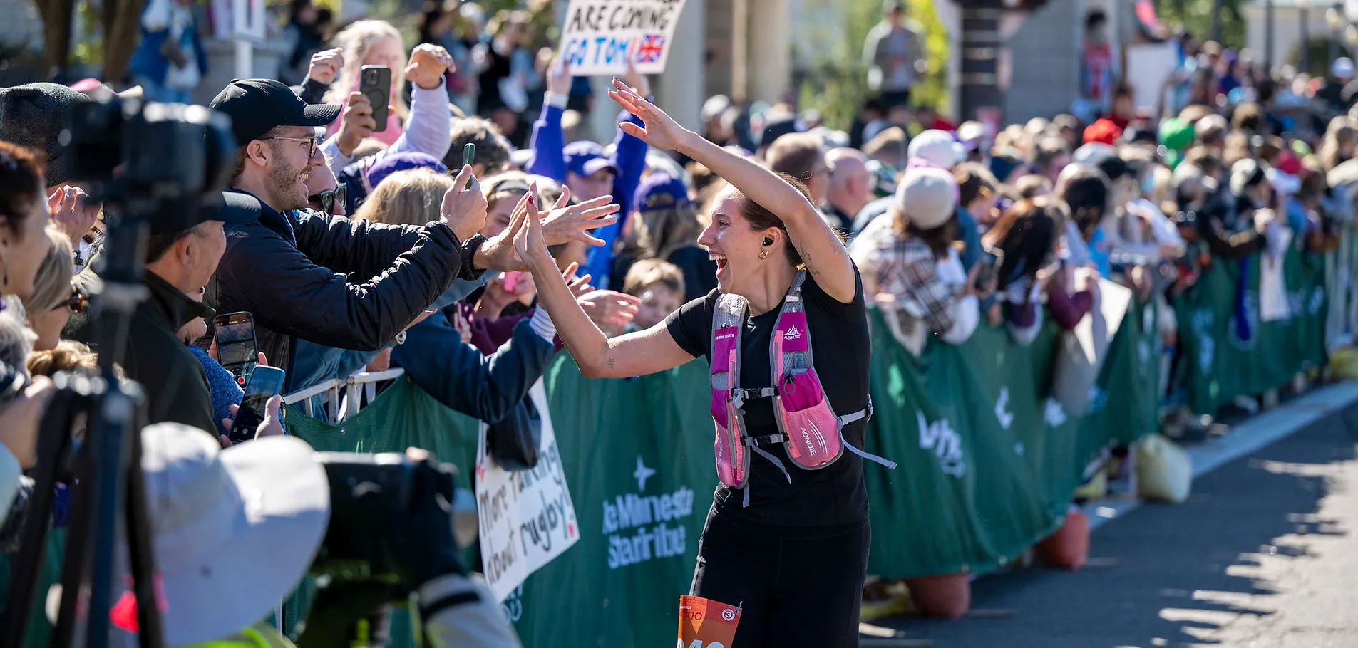 A running woman high-fives a crowd