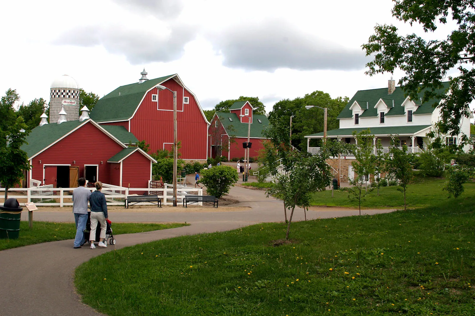 Several red farm buildings with a walking path