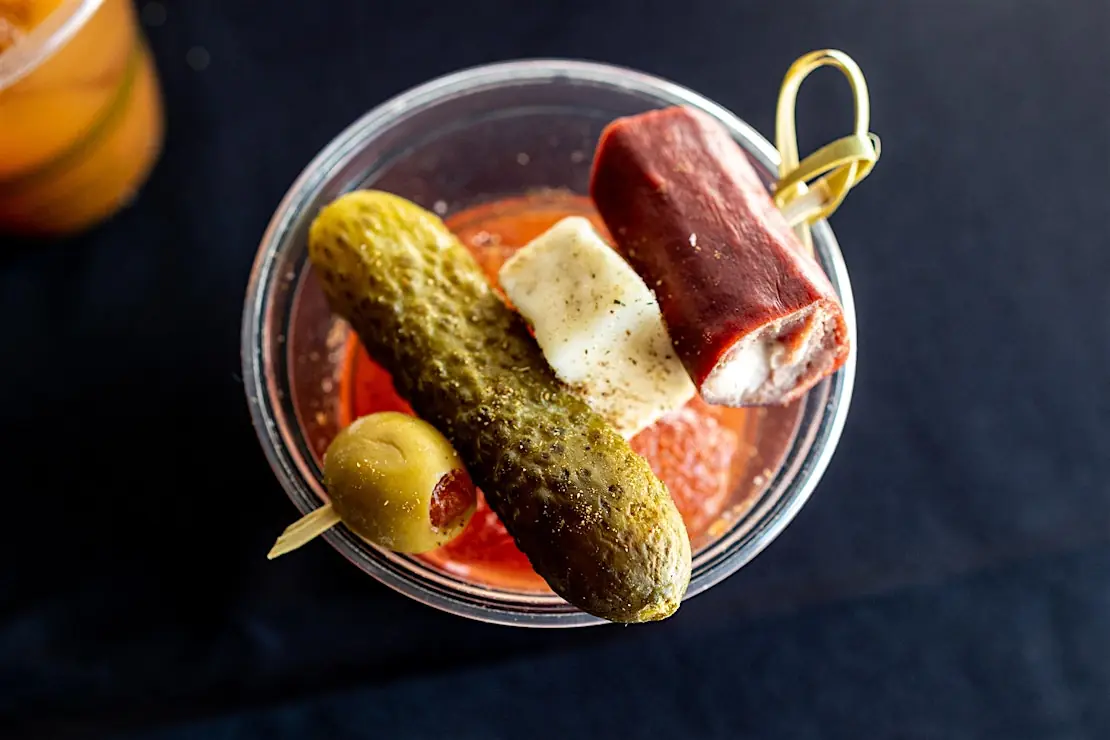 Bloody Mary with an olive, pickle, cheese, and sausage
