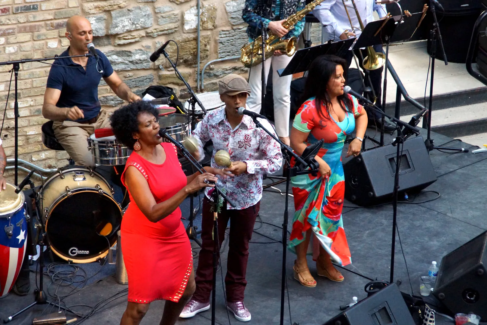 A group of musicians play instruments, sing, and dance on stage