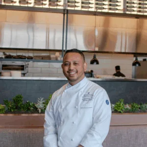 Executive Chef Kunal Dighe posed in front of the kitchen at Cedar + Stone, Urban Table.
